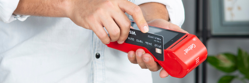 Persona deslizando una tarjeta bancaria en una terminal roja de Getnet