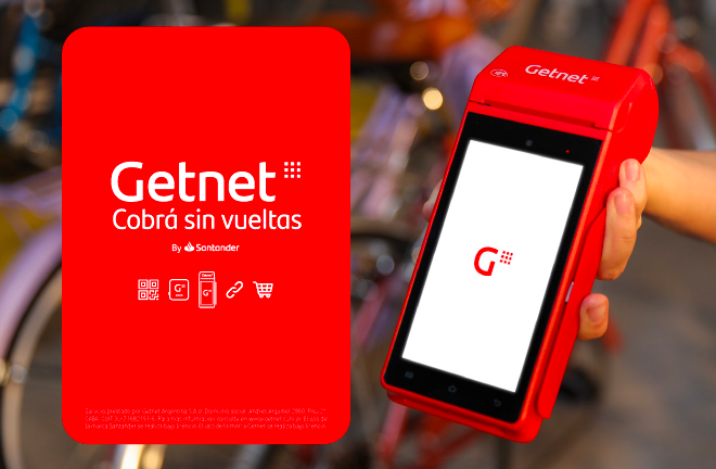 Mano sosteniendo una terminal de cobro Getnet roja con pantalla encendida mostrando el logo, junto a cartel rojo con texto 'Getnet. Cobrá sin vueltas'.