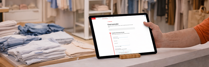 Tablet sobre un mostrador en una tienda de ropa, mostrando el Getnet Portal en la sección para crear un nuevo plan.