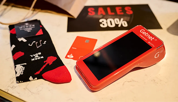 TPV Getnet, tarjeta del Banco Santander y calcetines de promoción sobre una mesa