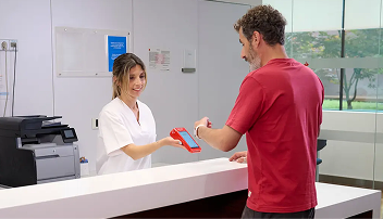 Cliente pagando con smartwatch en el TPV en una clínica
