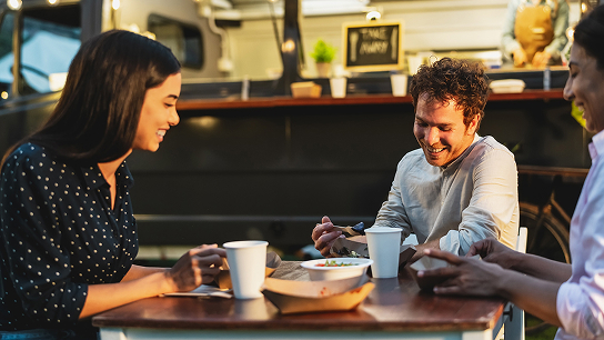 Tres amigos sonriendo en una cafetería