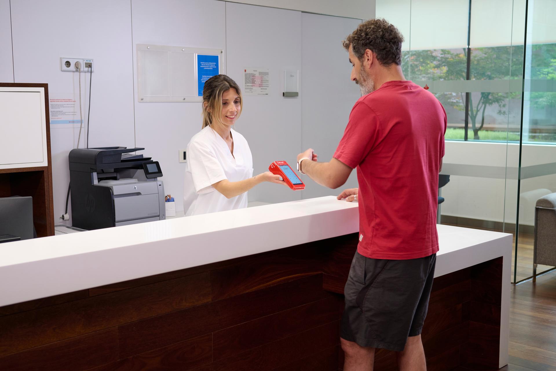 Señor pagando con smartwatch en una clínica 