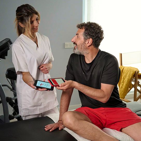 Señor pagando con el móvil en clínica de fisioterapia