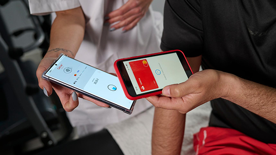 Cliente realizando un pago con el smartphone en el Terminal Tap on phone en una clínica