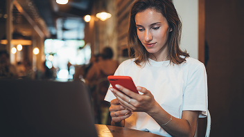 Mujer consultado el smartphone en un restaurante