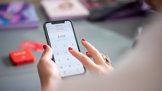 Mujer indicando importe en el smartphone para realizar un pago