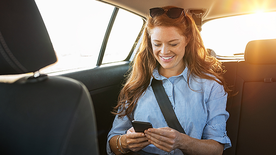 Mujer consultado el smartphone en un coche
