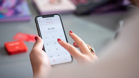 Manos de mujer tecleando importe en smartphone