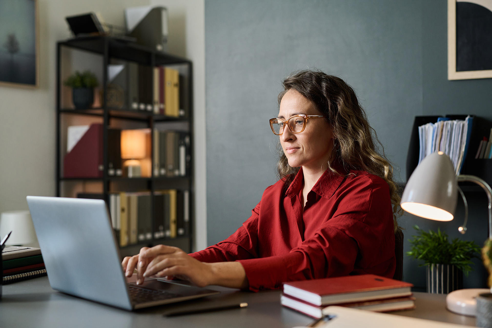 Mujer escribiendo en un portatil sobre una mesa